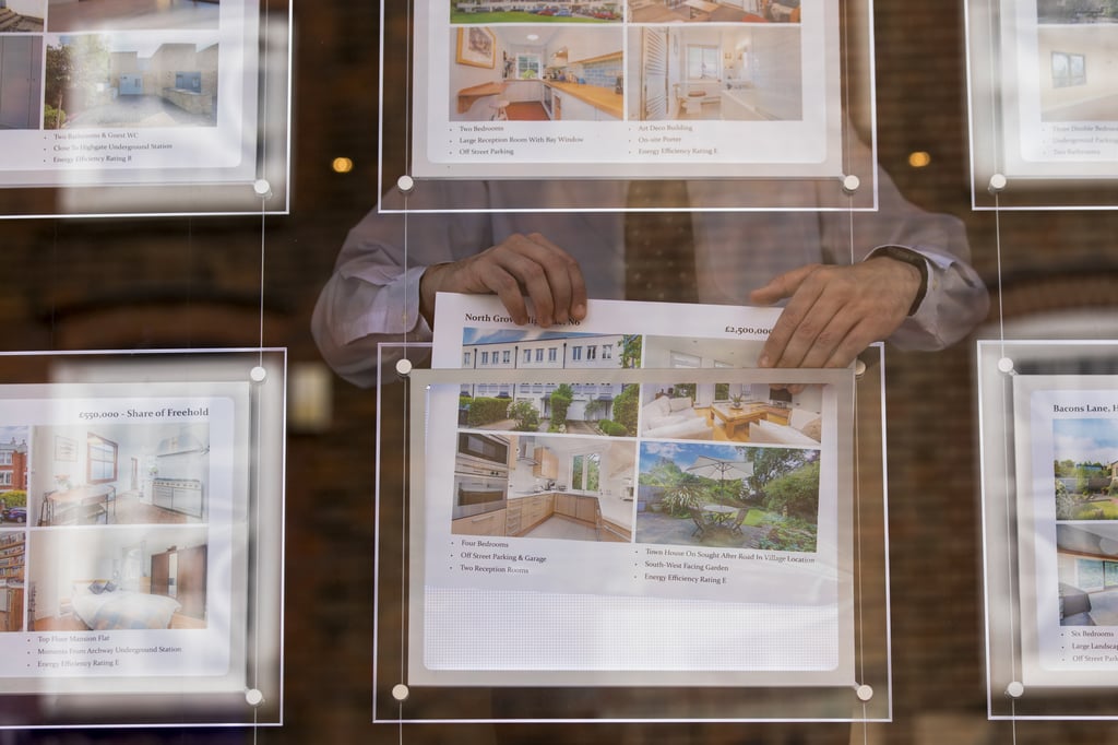 A estate agent changes a window display showing residential properties for sale in the Camden district of London. Photo: Bloomberg A estate agent changes a window display showing residential properties for sale in the Camden district of London. Photo: Bloomberg