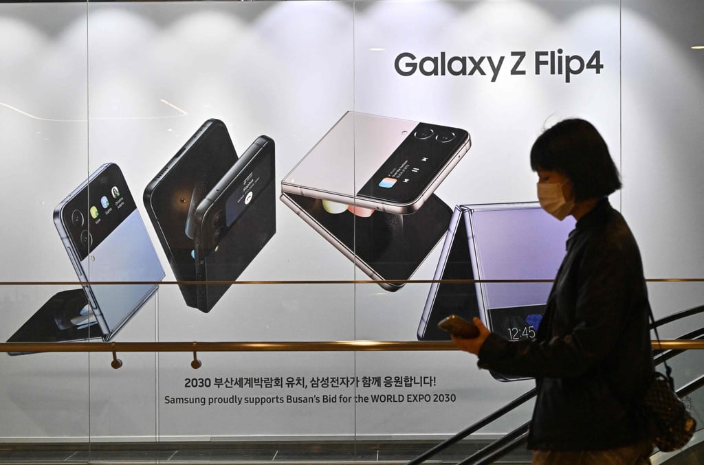 A woman walks past an advertisement for Samsung Electronics’ Galaxy Z Flip4 smartphone at the company’s Seocho building in Seoul on October 7, 2022. Photo: Agence France-Presse