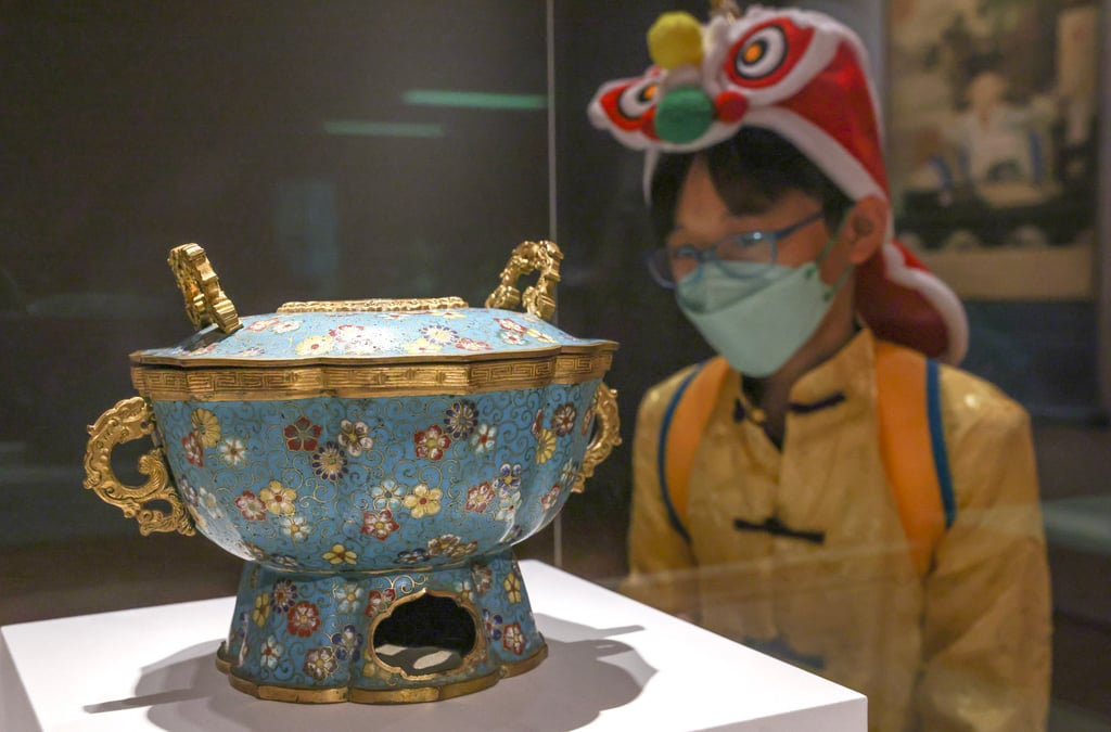 Jelly Wong, 10, a student at SKH Yuen Chen Maun Chen Jubilee Primary school, wears Lunar New Year garb while admiring Lunar New Year-themed items at Hong Kong Palace Museum in West Kowloon. Photo: May Tse