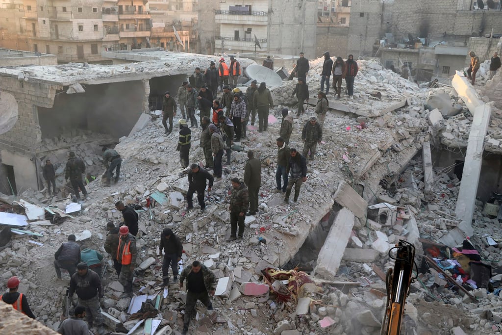 Civil defence workers and civilians work on the rubble of a destroyed building in the Sheikh Maksoud neighbourhood in Aleppo, Syria on Sunday. Photo: Hawar News Agency via AP