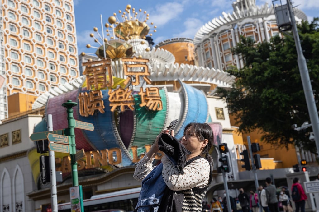 A mainland Chinese tourist takes photos outside the Lisboa Casino in Macau, on January 22. Macau borders reopened earlier this month. Photo: EPA-EFE