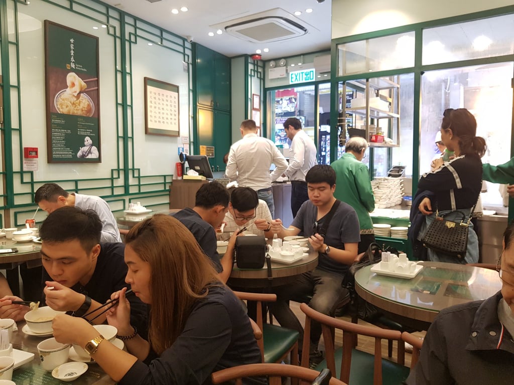 Tourists and locals have lunch in a busy noodle soup restaurant in the Sheung Wan district of Hong Kong. Photo: Shutterstock Tourists and locals have lunch in a busy noodle soup restaurant in the Sheung Wan district of Hong Kong. Photo: Shutterstock