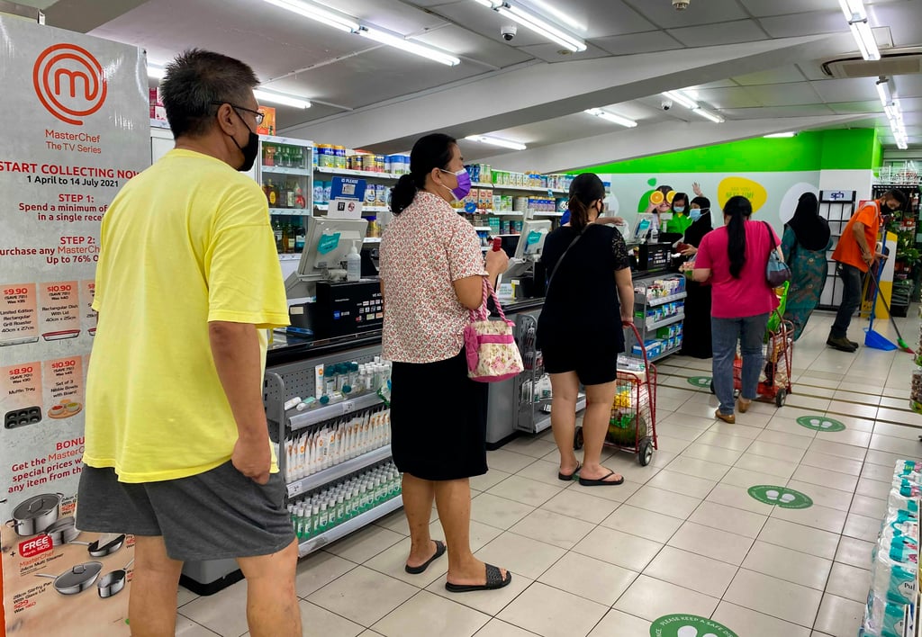 Shoppers observe social distancing at a supermarket in Singapore in 2021. Fatigue and other symptoms of long Covid can make it difficult for patients to complete even simple tasks like shopping for groceries. Photo: AP