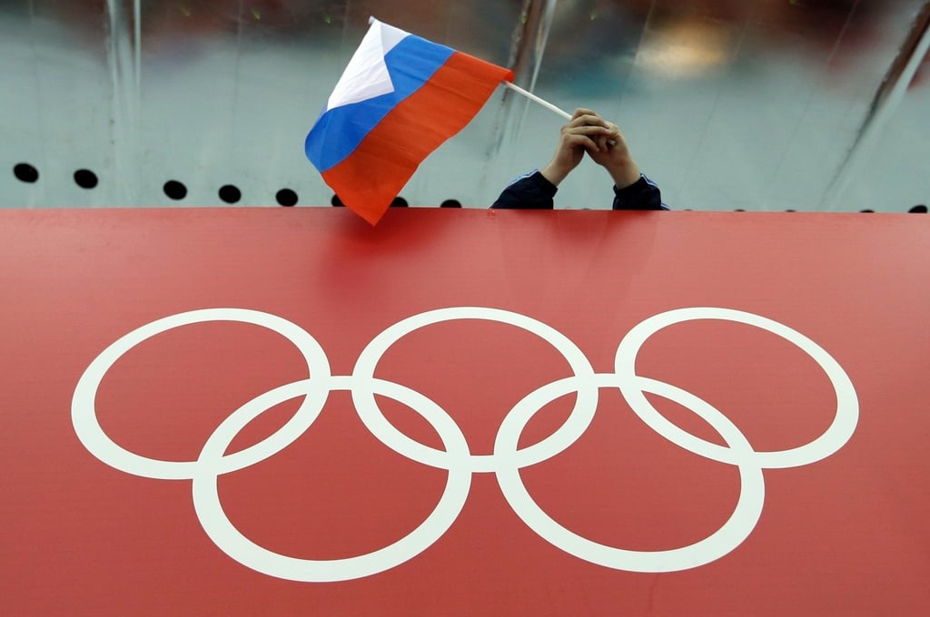 A Russian flag is held above the Olympic Rings at Adler Arena Skating Centre during the 2014 Winter Olympics in Sochi, Russia. Photo: AP
