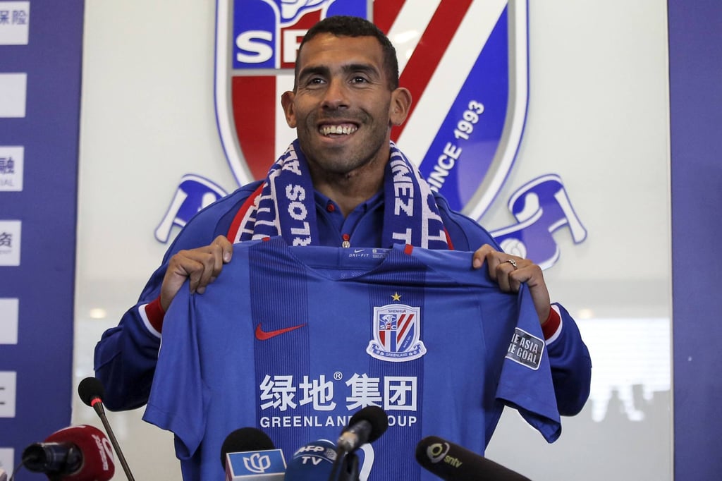 Carlos Tevez, poses with the jersey of his new club Shanghai Shenhua during a press conference to announce his signing. Photo: AFP