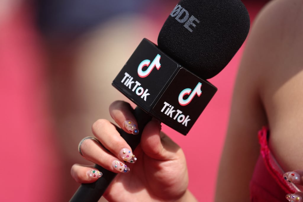A social influencer talks into a TikTok microphone on the red carpet during the Academy Awards in Hollywood, Los Angeles in March 2022. Photo: Reuters