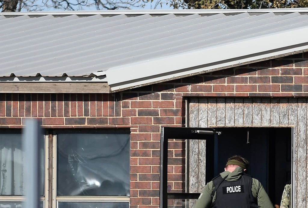 A law enforcement officer enters a residence near Hennesset, Oklahoma, on November 21, 2022. The home was the scene of a quadruple homicide. Photo: The Enid News & Eagle via AP