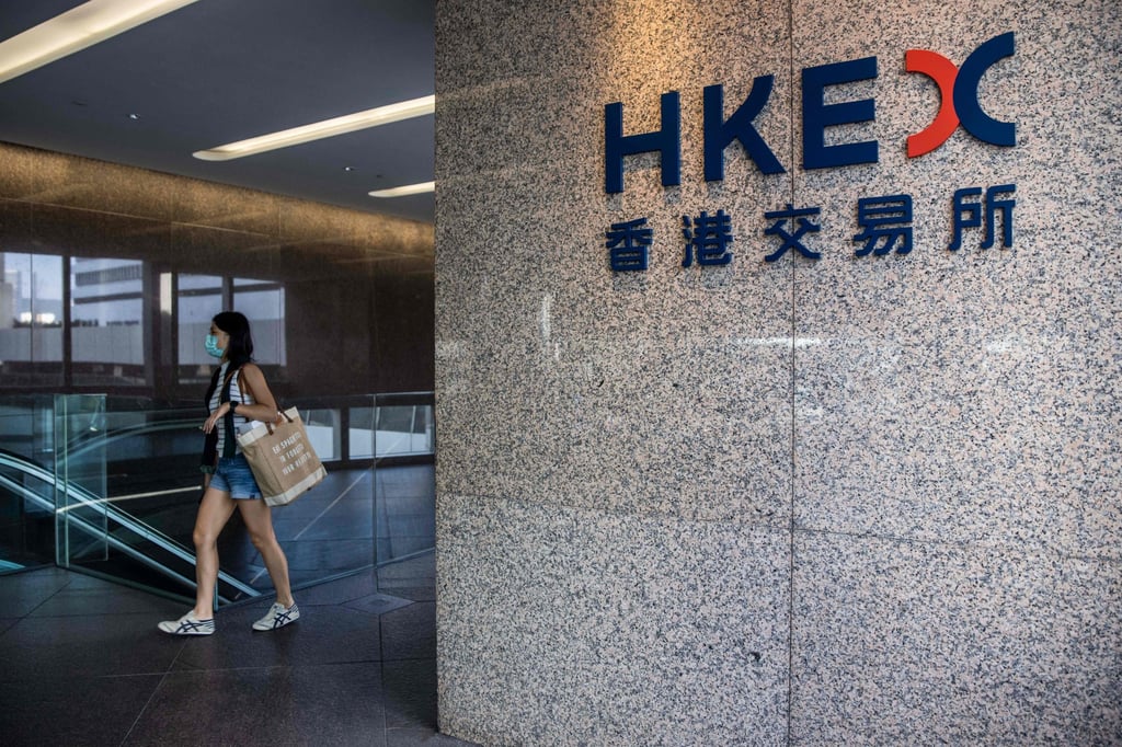 A woman walks past a Hong Kong Stock Exchange sign. The city’s IPOs by deal value could triple to about US$40 billion in 2023 driven by China’s reopening. Photo: AFP