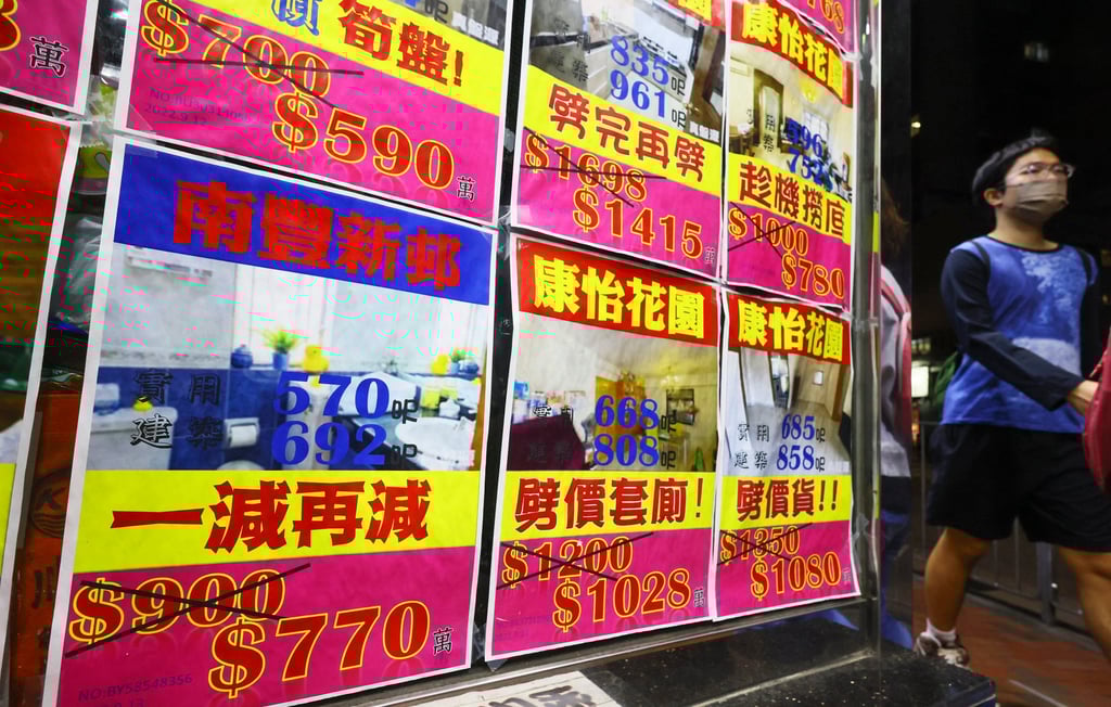 People walk past at residential property advertisements displayed in the window of an estate agency in Taikoo in October 2022. Photo: Dickson Lee