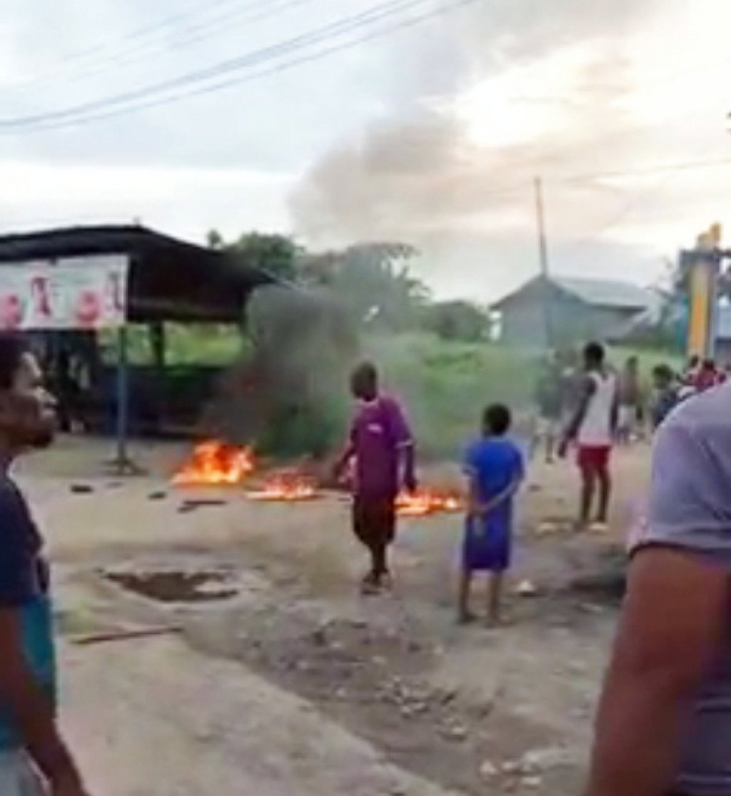 A crowd in Sorong, Papua, gathers around a woman who was accused of being a child abductor and set on fire. She died in hospital. Photo: Handout