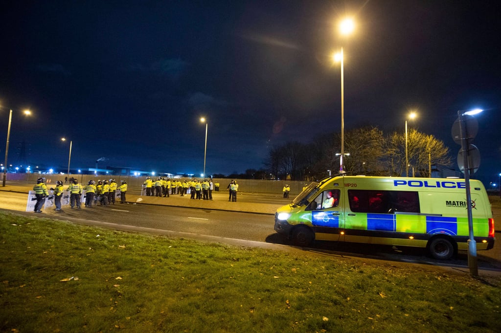 Police in riot gear gather after a protest outside the Suites Hotel in Knowsley, Merseyside, UK on Saturday. Photo: PA via AP
