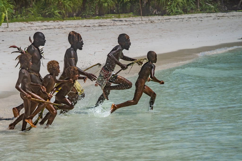Men and boys from the island of Loh stage a mock ambush as guests arrive on the shore. Photo: Sherry Ott