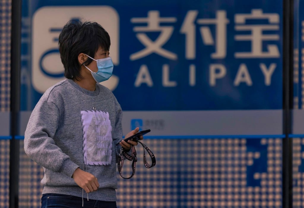 A woman walks past an Ant Group building in Shanghai. Photo: EPA-EFE A woman walks past an Ant Group building in Shanghai. Photo: EPA-EFE