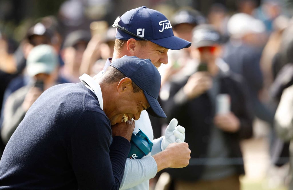 Tiger Woods laughs with Justin Thomas after handing him a tampon. Photo: AFP Tiger Woods laughs with Justin Thomas after handing him a tampon. Photo: AFP