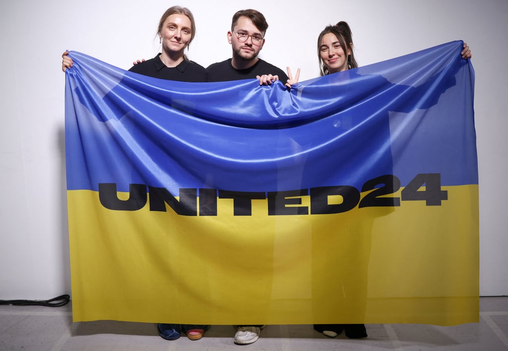 Ukrainian fashion designers Ksenia Schnaider, Ivan Frolov and Julie Paskal pose backstage with a Ukraine flag ahead of the Ukraine Fashion Week show during which they presented their labels’ designs at London Fashion Week in Britain. Photo: Reuters Ukrainian fashion designers Ksenia Schnaider, Ivan Frolov and Julie Paskal pose backstage with a Ukraine flag ahead of the Ukraine Fashion Week show during which they presented their labels’ designs at London Fashion Week in Britain. Photo: Reuters