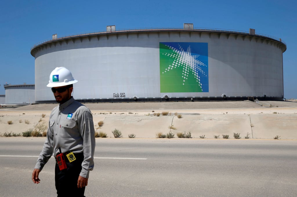 A Saudi Aramco employee walks near an oil tank at the company’s Ras Tanura oil refinery and oil terminal in Saudi Arabia in May 2018. Photo: Reuters