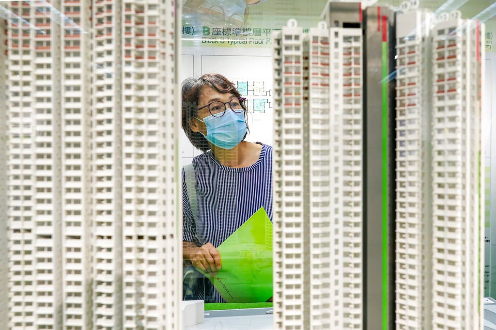 A potential buyer holding a green form views a model at the Housing Authority. Photo: Yik Yeung-man