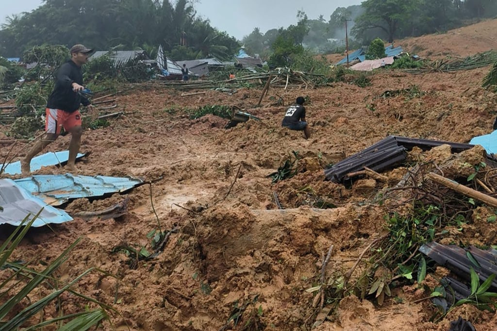 People inspect the site where a landslide hit a village on Indonesia’s Serasan Island on Monday, killing a number of people. Photo: BNPB via AP People inspect the site where a landslide hit a village on Indonesia’s Serasan Island on Monday, killing a number of people. Photo: BNPB via AP