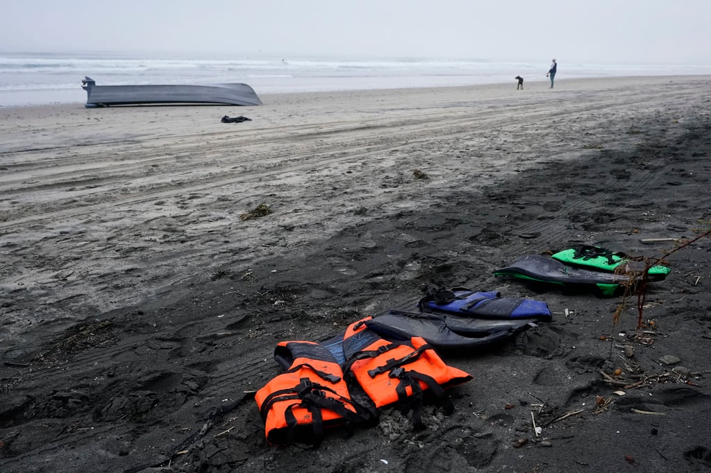 A boat sits overturned near a row of life jackets on Blacks Beach in San Diego, California, US on Sunday. Photo: AP A boat sits overturned near a row of life jackets on Blacks Beach in San Diego, California, US on Sunday. Photo: AP