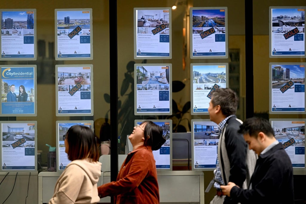 People walk past a property agent’s window in Melbourne earlier this month. Chinese investment in Australia, mainly in real estate, peaked between 2014 and 2016. Photo: AFP