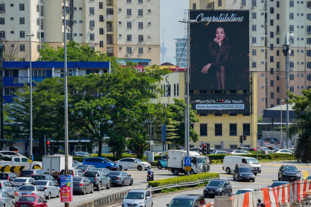 Motorists in Kuala Lumpur pass by a giant electronic billboard set up to congratulate Michelle Yeoh. Photo: AP Motorists in Kuala Lumpur pass by a giant electronic billboard set up to congratulate Michelle Yeoh. Photo: AP