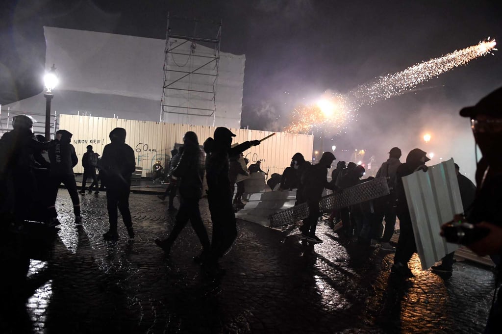 A protester shoots a firework at oolice officers during a demonstration on Place de la Concorde in Paris on March 17, 2023. Photo: AFP