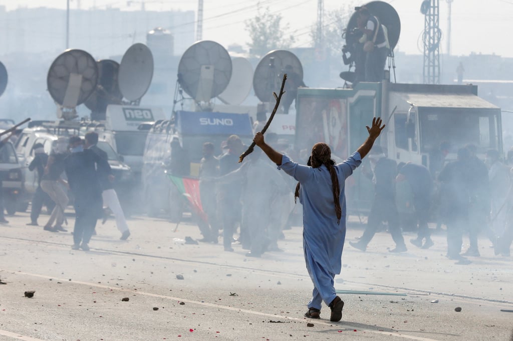 A supporter of former Pakistan prime minister Imran Khan gestures amid tear gas smoke during a clash outside the Federal Judicial Complex in Islamabad, Pakistan on Saturday. Photo: Reuters