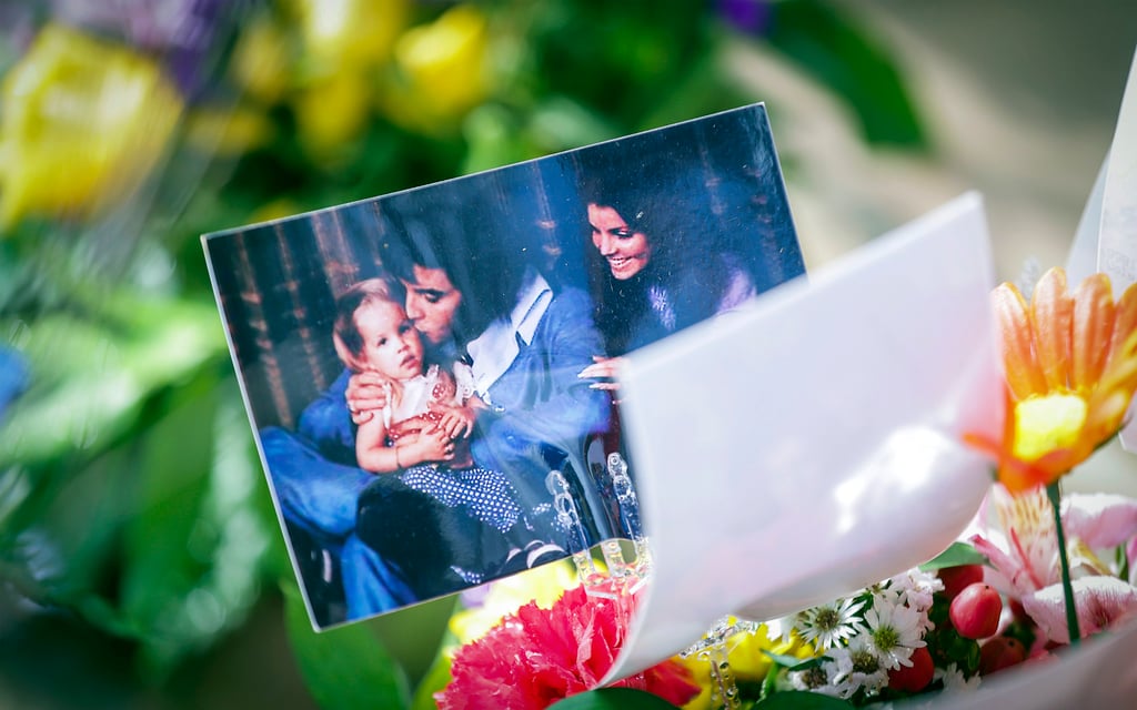 A photo of a young Lisa Marie Presley with her parents, Elvis Presley and Priscilla Presley, sits atop a bouquet of flowers during a memorial service at Graceland in Memphis, on January 22. Photo: AP A photo of a young Lisa Marie Presley with her parents, Elvis Presley and Priscilla Presley, sits atop a bouquet of flowers during a memorial service at Graceland in Memphis, on January 22. Photo: AP