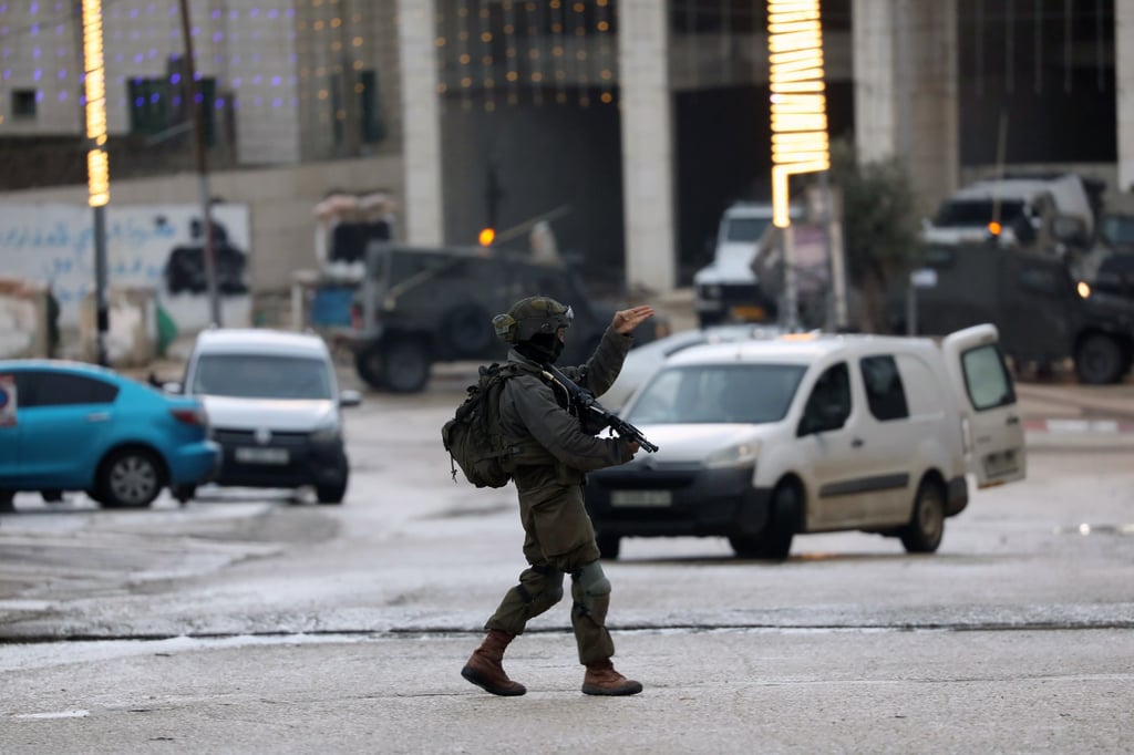 An Israeli soldier guards the area following a shooting attack in the West Bank town of Hawara, near the city of Nablus, on Sunday. Photo: EPA-EFE