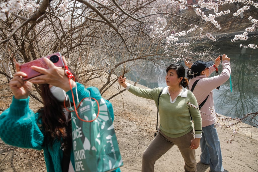Visitors take selfies with their mobile phones in Beijing. Photo: EPA-EFE Visitors take selfies with their mobile phones in Beijing. Photo: EPA-EFE