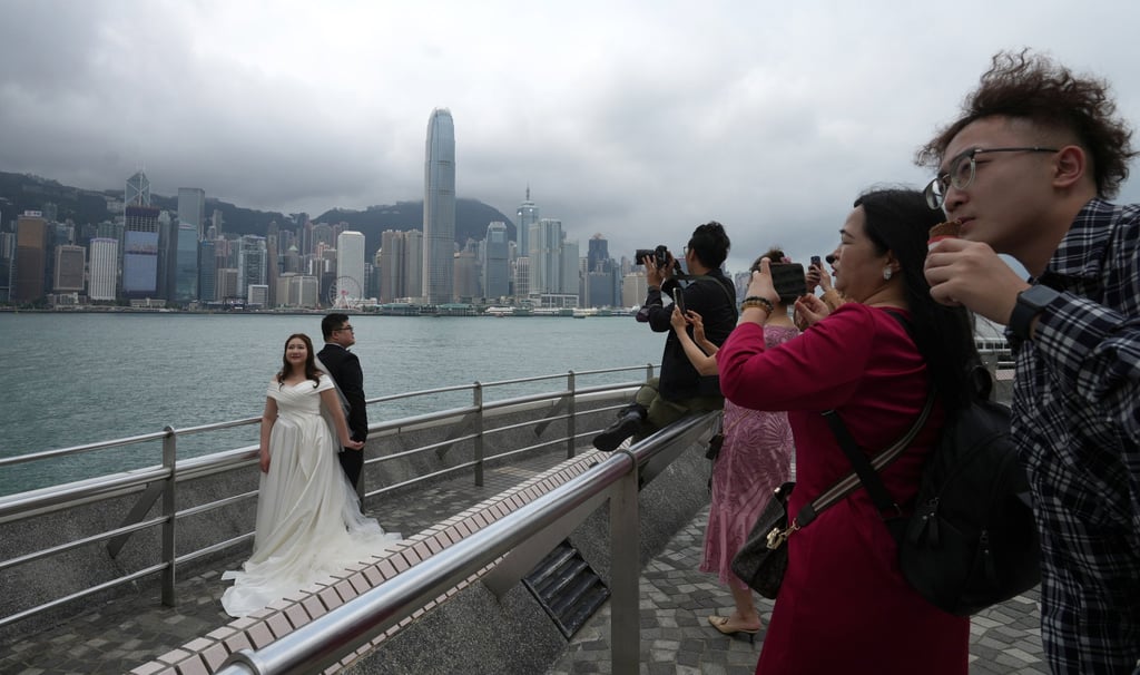 A bride and groom pose for pictures in Tsim Sha Tsui along the waterfront. Photo: Sam Tsang