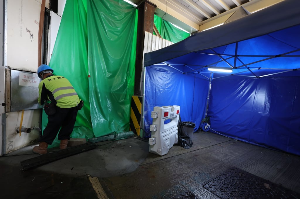 A worker stands by a sealed-off section of Tuen Mun Hospital on Saturday. Photo: Yik Yeung-man A worker stands by a sealed-off section of Tuen Mun Hospital on Saturday. Photo: Yik Yeung-man