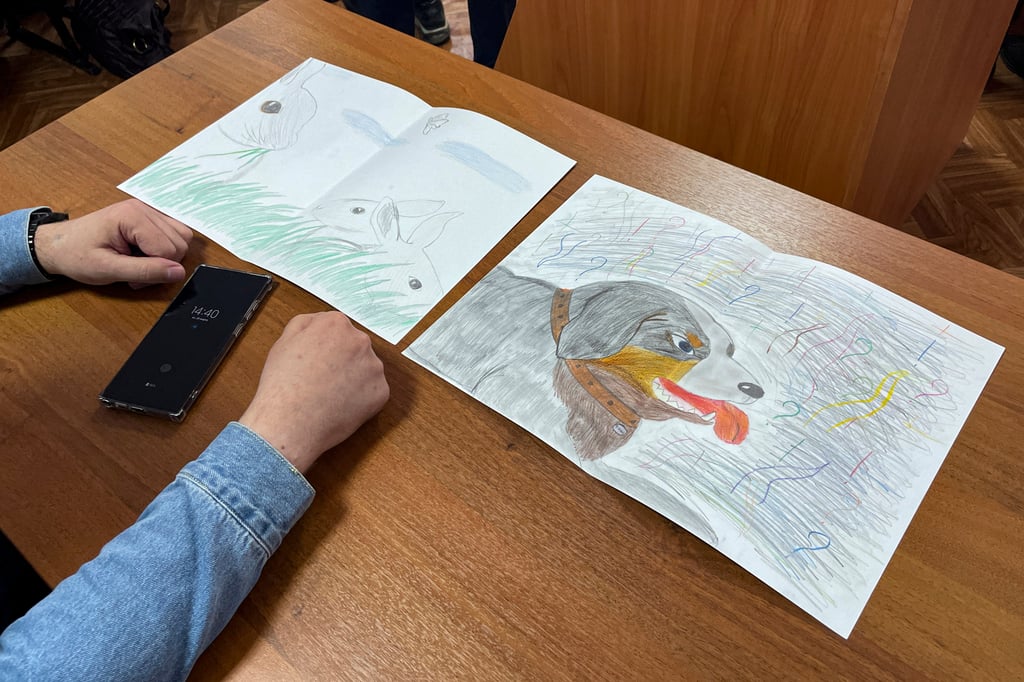 Moskalyov’s lawyer Vladimir Biliyenko shows pictures Masha drew for her father, Alexei Moskalyov, in a courtroom in Yefremov, in Russia’s Tula region on Monday. Photo: AP Moskalyov’s lawyer Vladimir Biliyenko shows pictures Masha drew for her father, Alexei Moskalyov, in a courtroom in Yefremov, in Russia’s Tula region on Monday. Photo: AP
