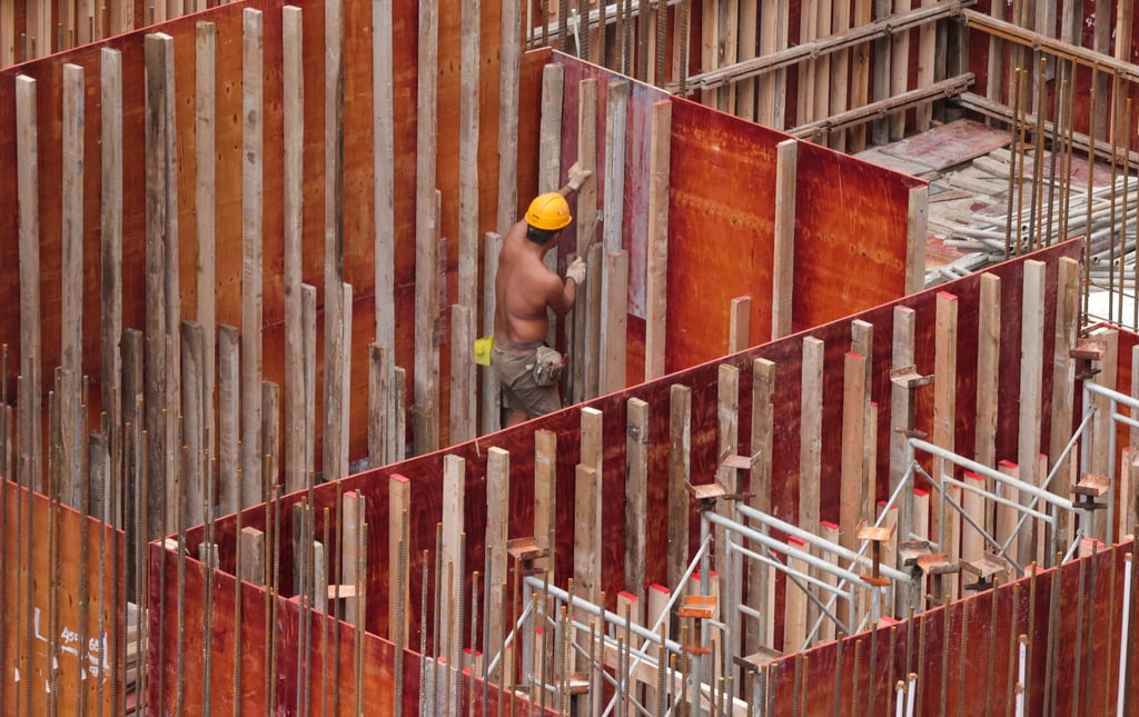 Site workers erect formwork at a construction site in Mong Kok. Amid a severe manpower shortage, the Hong Kong government must study ways to import workers for some industries without compromising the job opportunities of locals. Photo: Jelly Tse Site workers erect formwork at a construction site in Mong Kok. Amid a severe manpower shortage, the Hong Kong government must study ways to import workers for some industries without compromising the job opportunities of locals. Photo: Jelly Tse