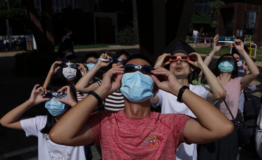 Residents wearing solar viewers check out a partial solar eclipse at the Kwun Tong Promenade in 2020. Photo: Sam Tsang
