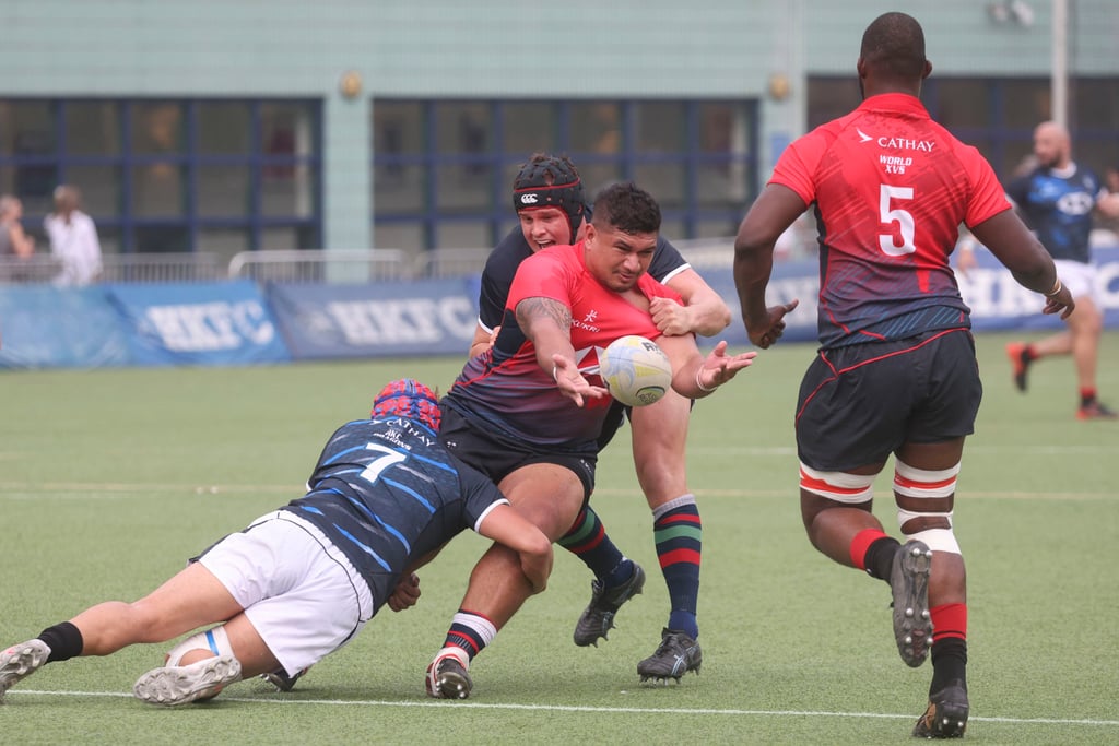 World XV’s Sunia Fameitau offloads the ball to teammate Nyasha Tarusenga (right) while being tackled by Anselm Chan during the match at Hong Kong Football Club. Photo: Yik Yeung-man
