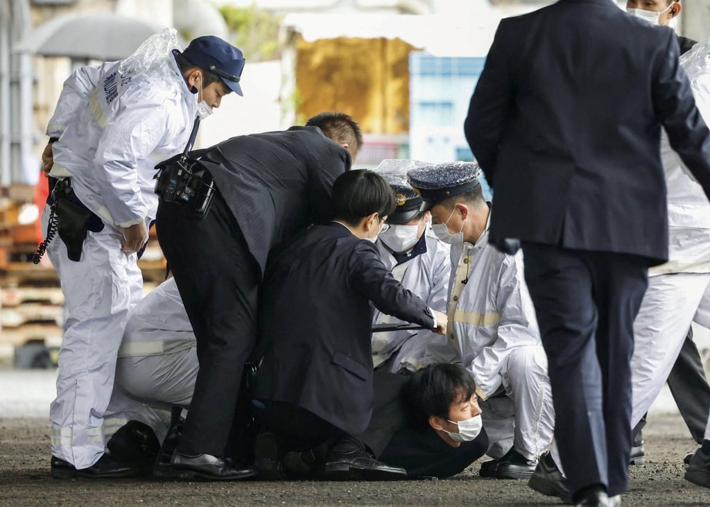 Security officers restrain Ryuji Kimura, the suspect in Saturday’s attack in Saikazaki, Wakayama prefecture. Photo: Kyodo via Reuters