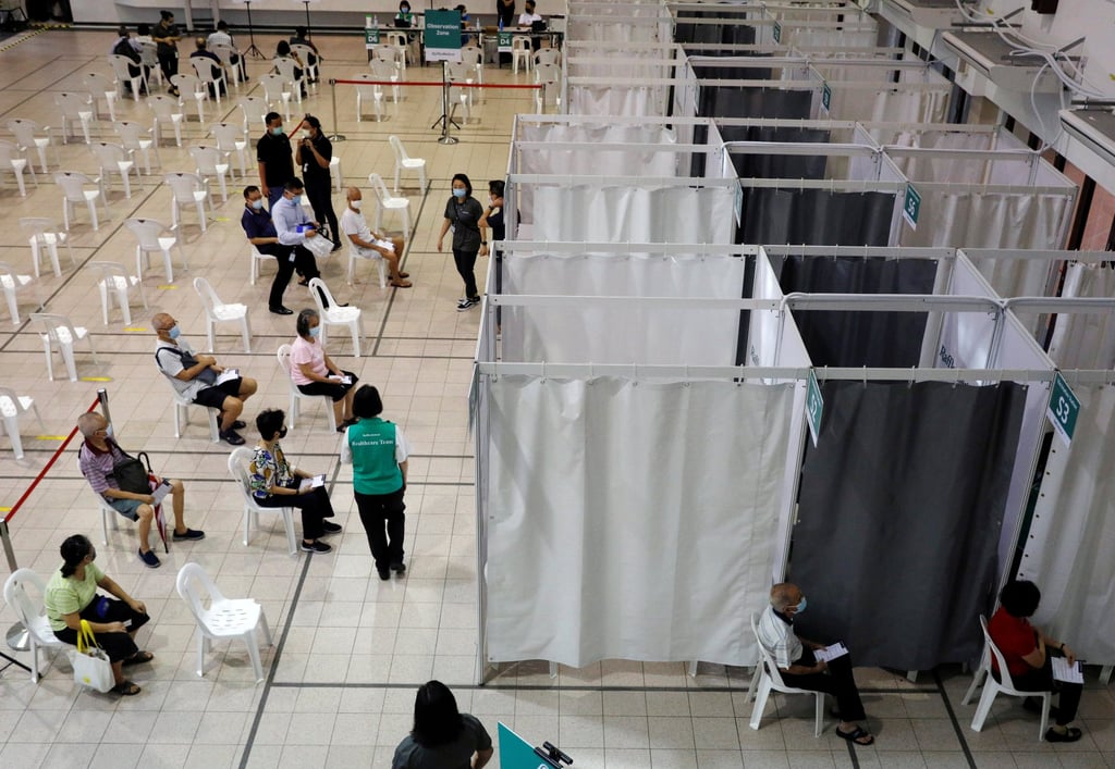 People wait to receive a dose of Covid-19 vaccine at a vaccination centre in Singapore in 2021. Photo: Reuters People wait to receive a dose of Covid-19 vaccine at a vaccination centre in Singapore in 2021. Photo: Reuters