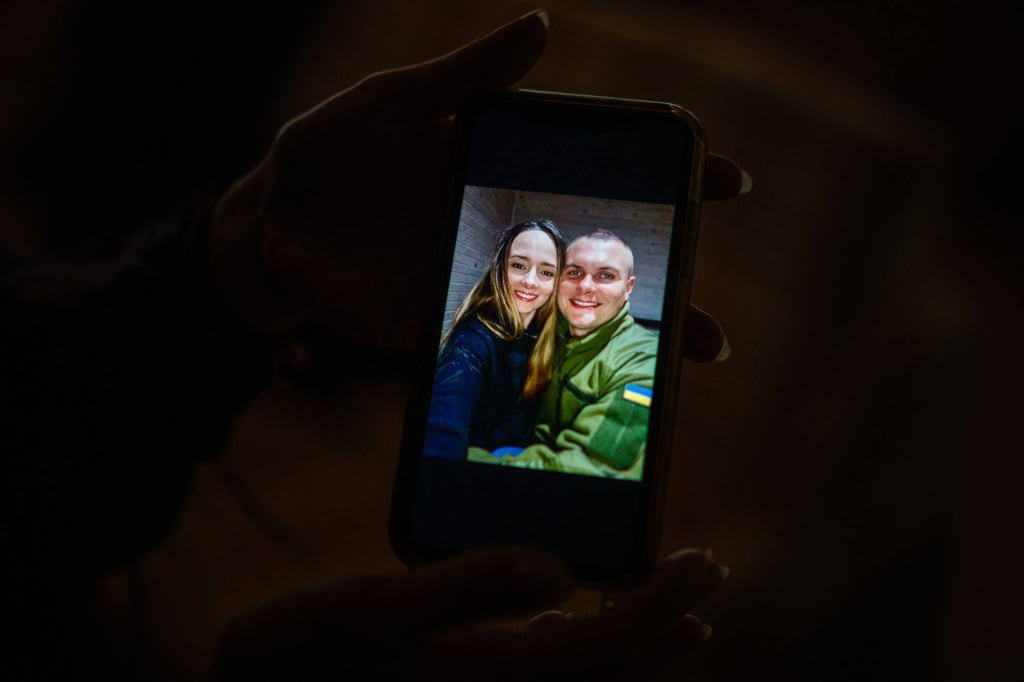 Ukrainian Olga Slyshyk shows her phone with a picture of her and her late husband Mykhailo. Photo: AFP