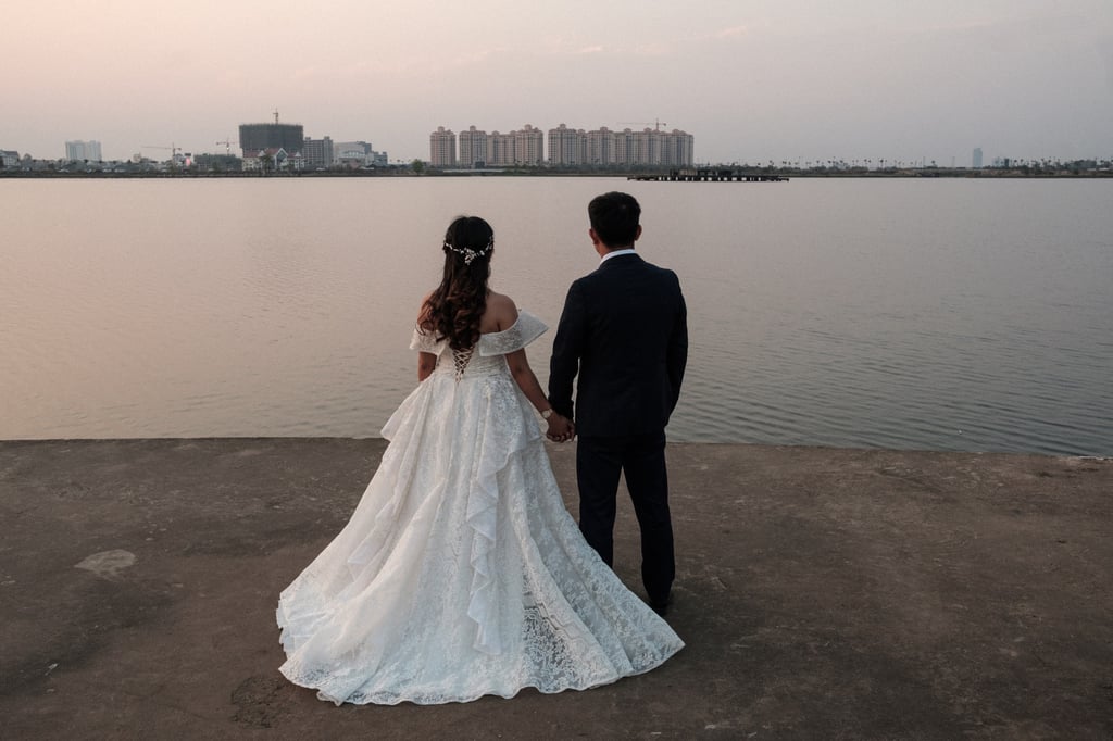 A couple stare at the artificial lake within the That Luang Lake SEZ on their wedding day. The lakeside has become a popular spot for wedding photo shoots. Photo: Nicholas Bosoni