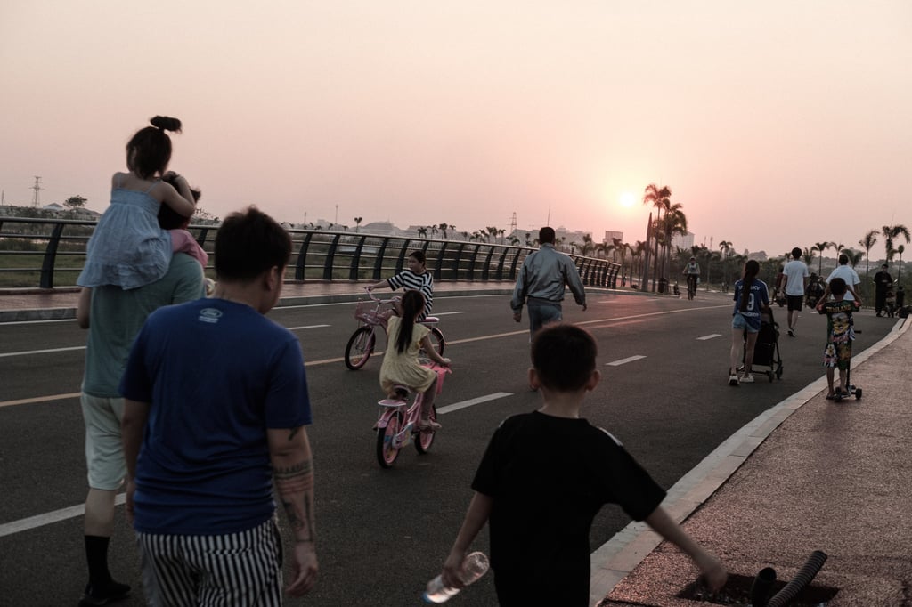 Families gather around That Luang artificial lake on the outskirts of Vientiane for a sunset stroll and exercise. The lake has become an important public space for the Laos capital’s growing middle class. Photo: Nicholas Bosoni