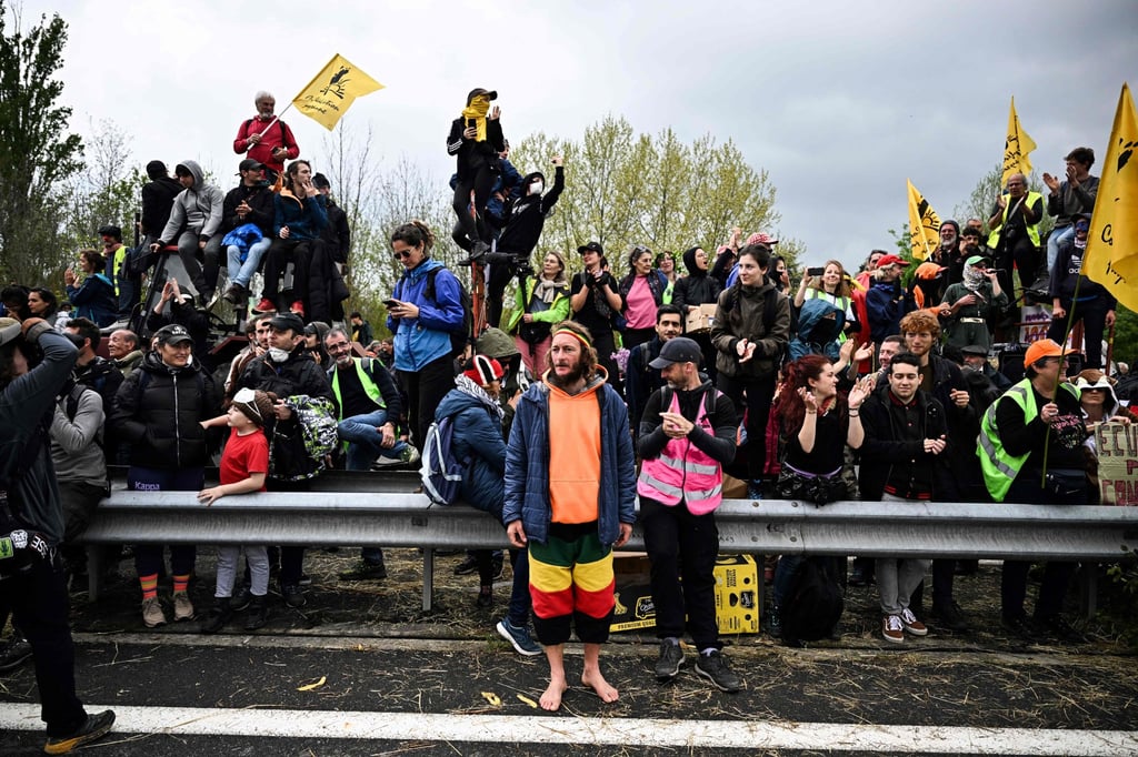 Protesters hold flags as they march on an arterial road during a demonstration against the A69 motorway project between Castres and Toulouse, near Soual, southwestern France, on Saturday. Photo: AFP