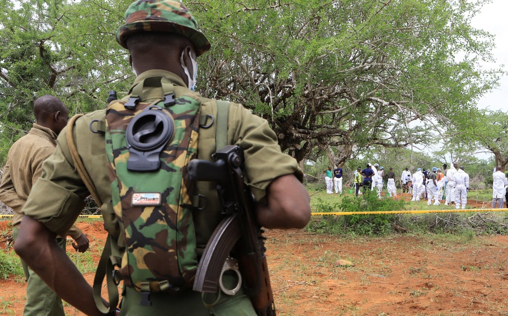 Kenya police officers stand guard as forensic experts and police exhume bodies of suspected members of a Christian cult in Shakahola forest, Kilifi county, Kenya on Saturday. Photo: Reuters