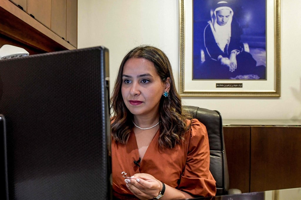 Faten Mattar of Mattar Jewelers looks up information for an item on her computer monitor, while behind her is shown a framed picture of her grandfather, Khalifa bin Ibrahim bin Salman Mattar, during an interview at the House of Pearls shop in Manama, on March 19.