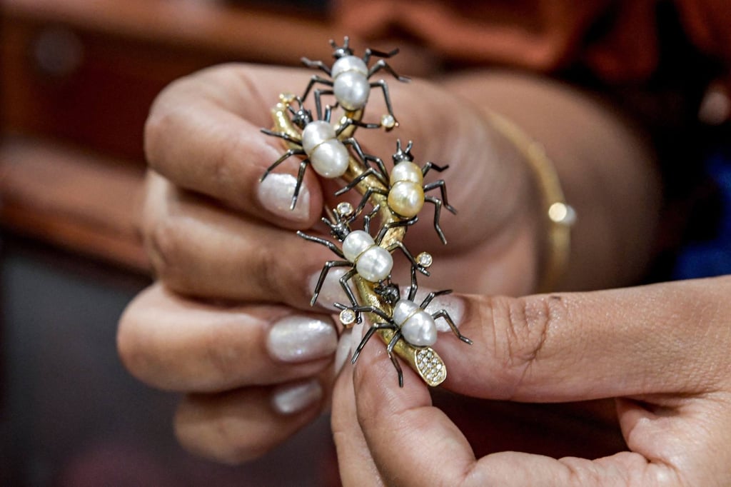 Faten Mattar of Mattar Jewelers displays an ant-shaped brooch made of natural pearls and 18k yellow gold at the House of Pearls shop in Manama, on March 19.