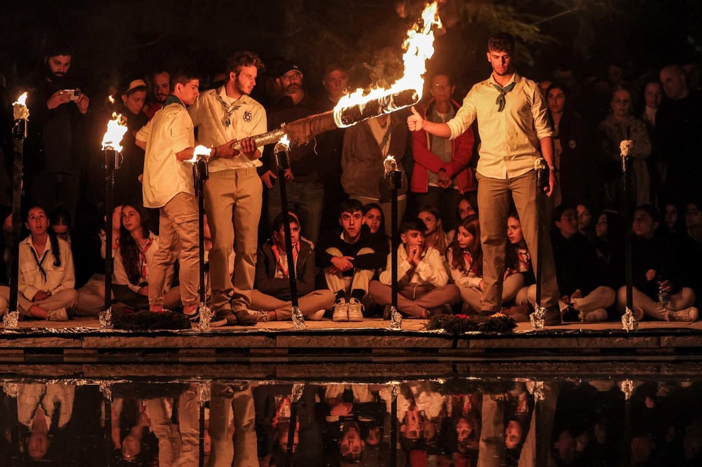 Israeli scouts light torches during a ceremony to commemorate fallen soldiers at the Mount Herzl military cemetery in Jerusalem on Monday. Photo: AFP Israeli scouts light torches during a ceremony to commemorate fallen soldiers at the Mount Herzl military cemetery in Jerusalem on Monday. Photo: AFP