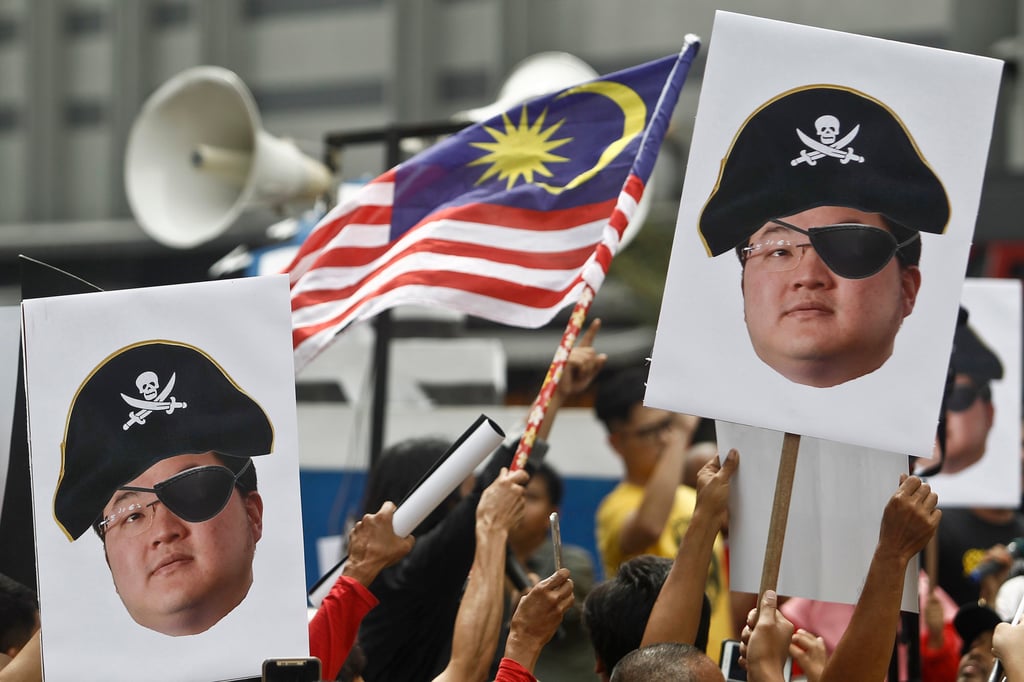 Protesters hold portraits of financier Jho Low depicted as a pirate during a protest in Kuala Lumpur, Malaysia in April 2018. Photo: AP Protesters hold portraits of financier Jho Low depicted as a pirate during a protest in Kuala Lumpur, Malaysia in April 2018. Photo: AP