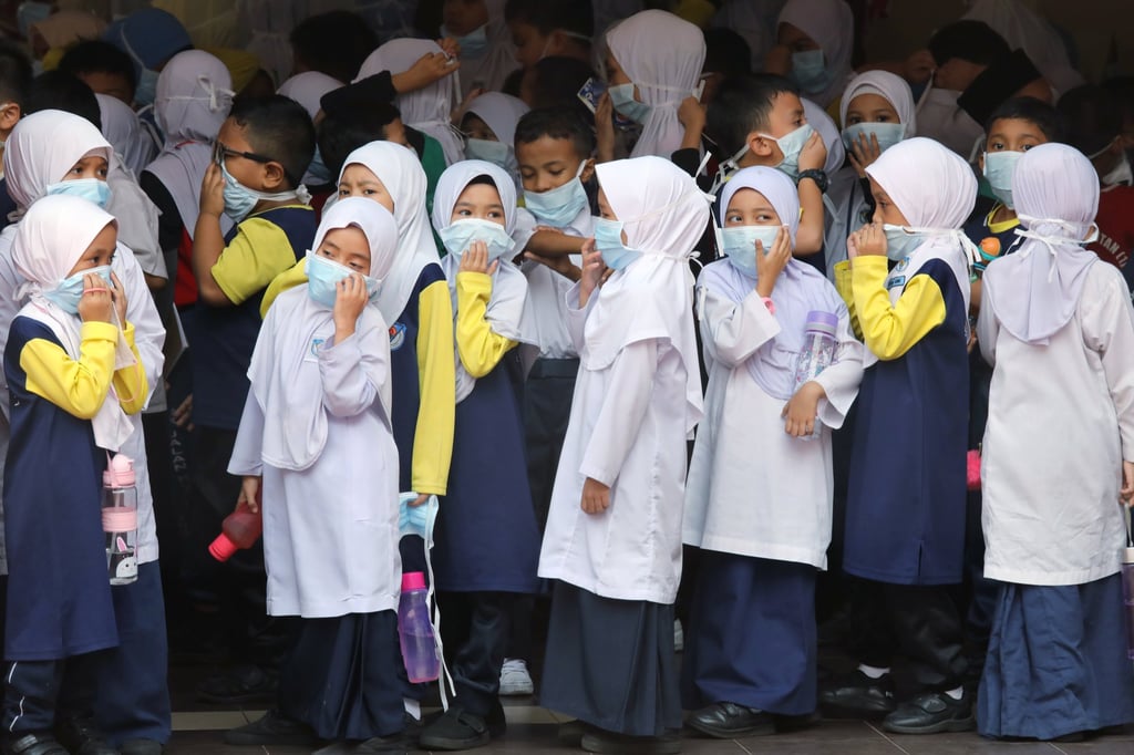 Students cover their faces with masks at a school in Kuala Lumpur, Malaysia. Photo: Reuters