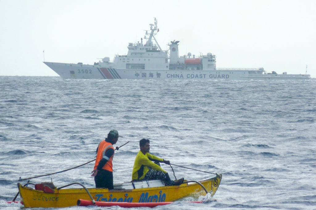 Filipino fishermen aboard a wooden boat sail past a Chinese coastguard ship in the Scarborough Shoal area of the South China Sea last year. Photo: AFP via Getty Images/TNS Filipino fishermen aboard a wooden boat sail past a Chinese coastguard ship in the Scarborough Shoal area of the South China Sea last year. Photo: AFP via Getty Images/TNS