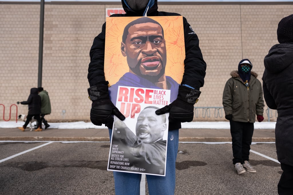 A protester holds a poster of George Floyd during a rally on Martin Luther King Jr. Day. Photo: Getty Images